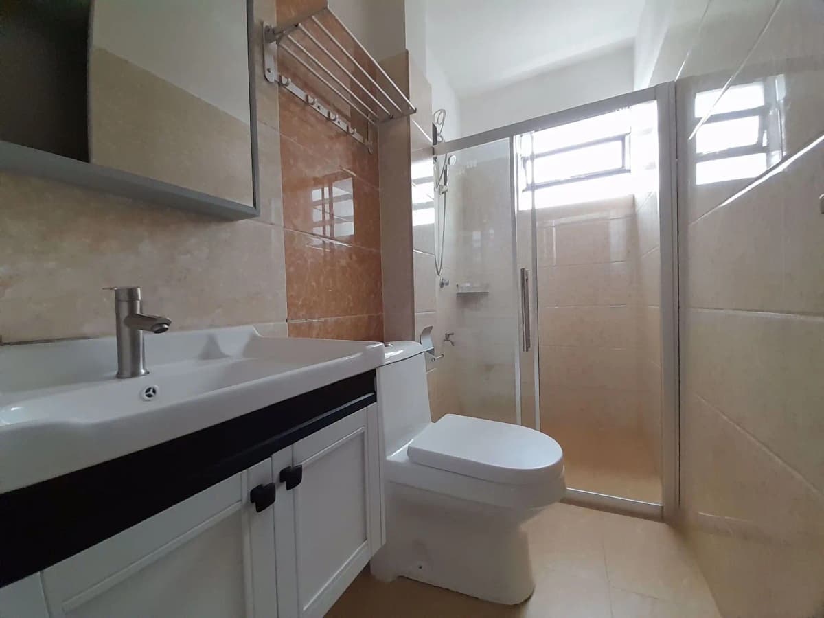 Modern bathroom with white sink, toilet, and glass shower enclosure