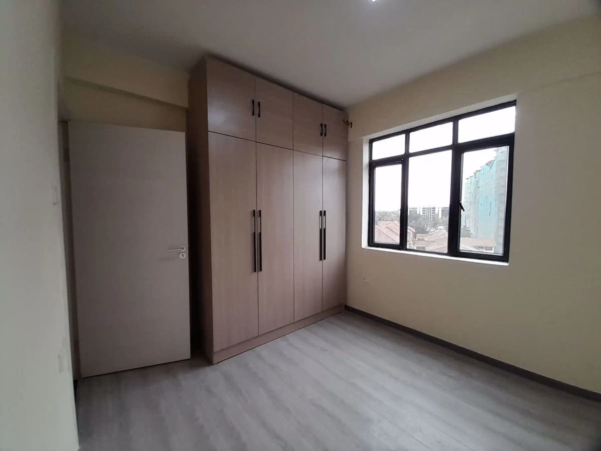 Spacious bedroom with built-in wardrobes and city views