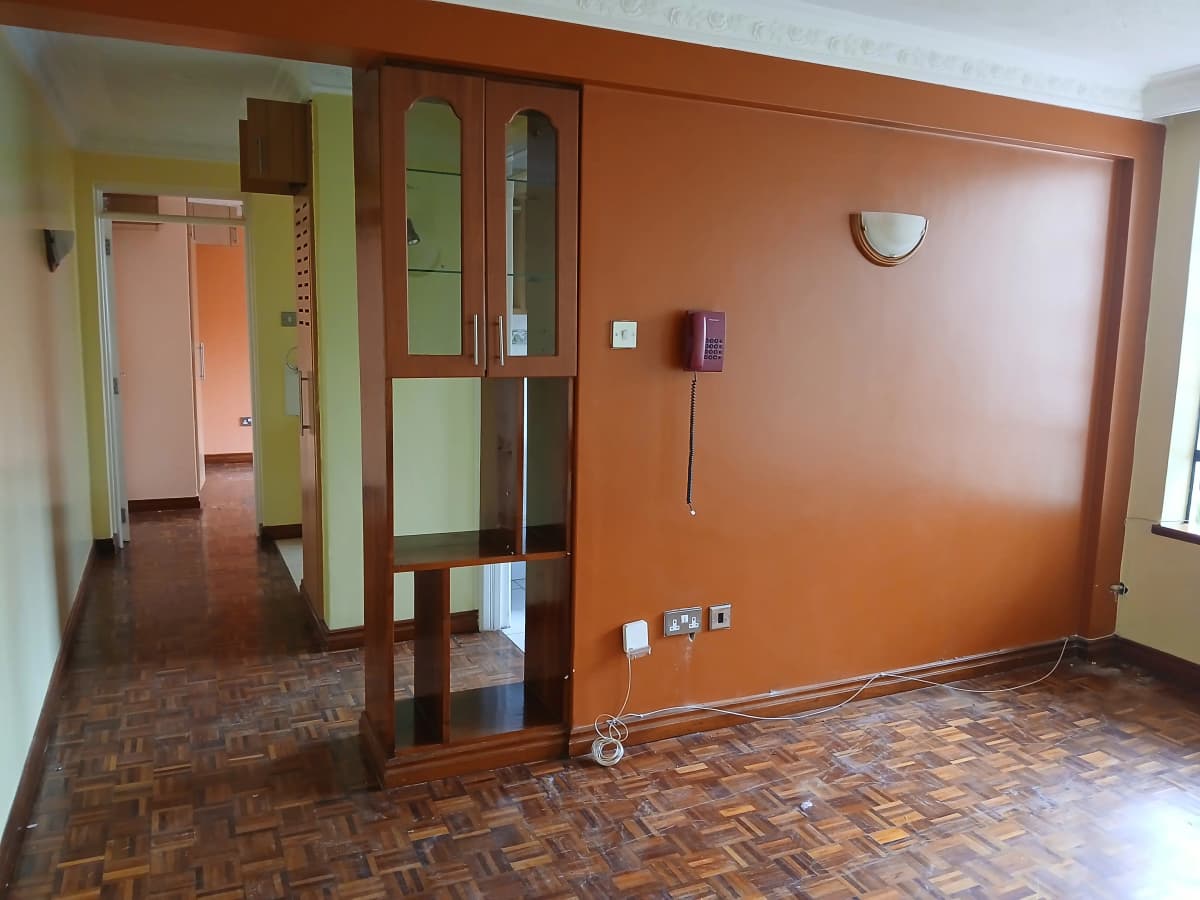 Open living space with orange accent wall and wooden room divider