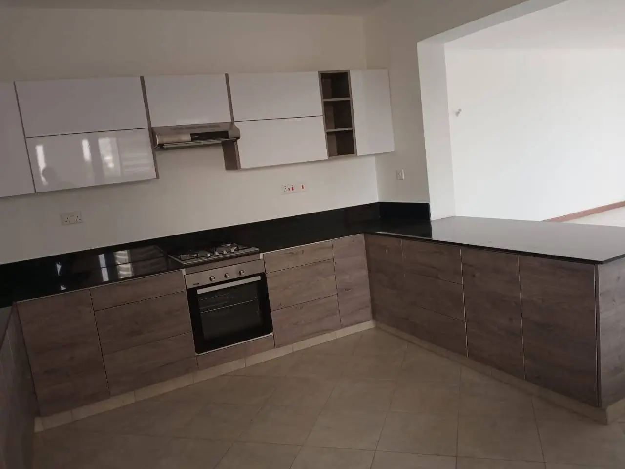 Modern L-shaped kitchen with black countertops and white cabinetry