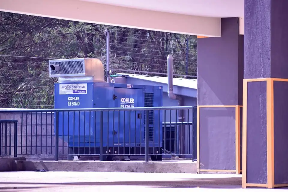 Blue industrial generator or utility equipment behind metal railing