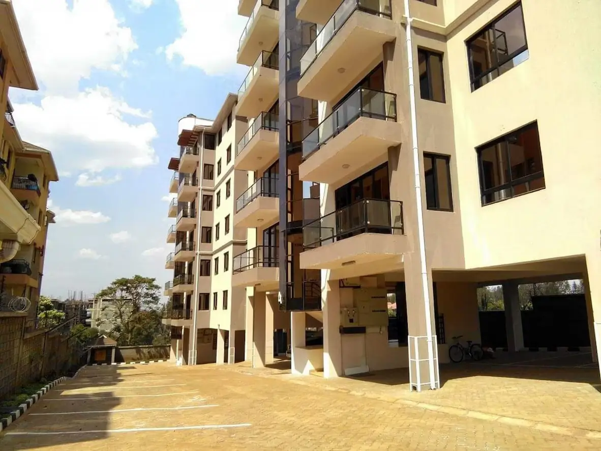 Modern residential building with paved compound and parking area