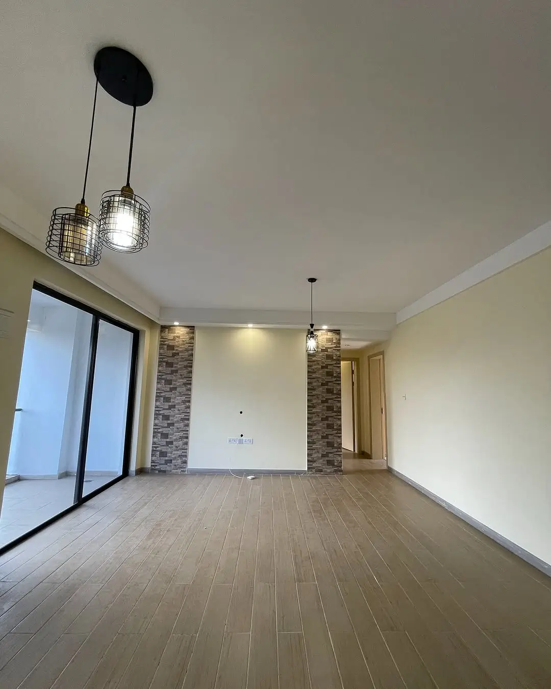 Spacious living room with wooden flooring and sliding glass doors