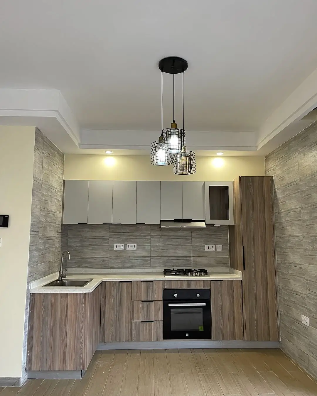 Modern L-shaped kitchen with gray tile backsplash and pendant lights