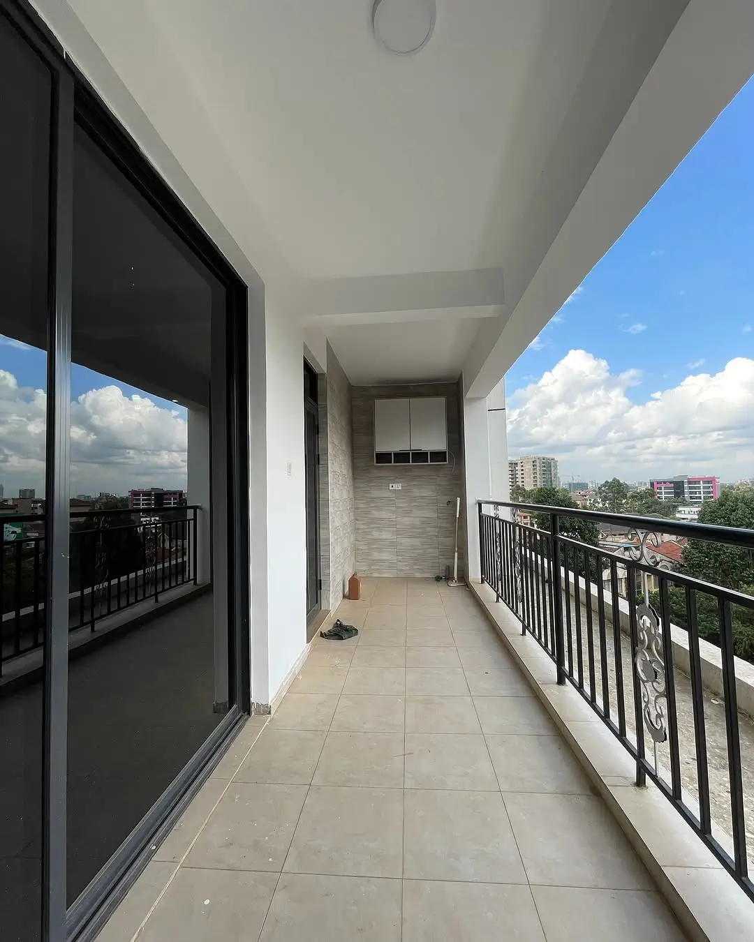 Spacious elevated balcony with city skyline views and metal railings