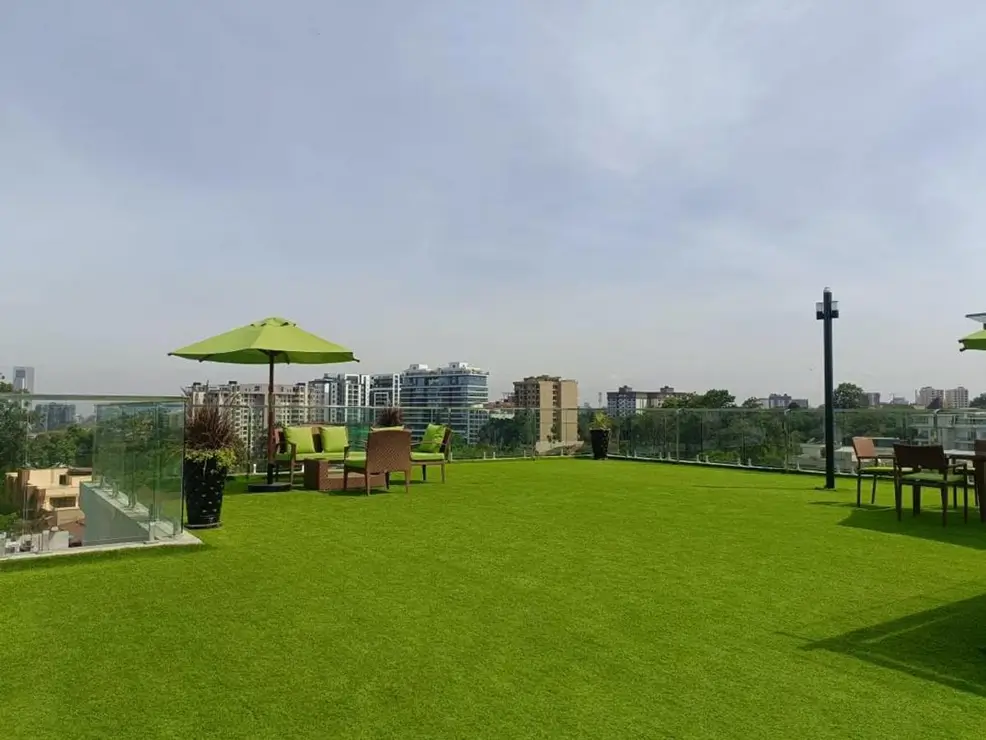 Expansive rooftop lawn with lime umbrella and city views