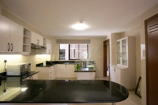 Modern kitchen with black granite countertops and white cabinetry