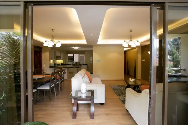 Open-plan living area with kitchen visible, modern ceiling lighting
