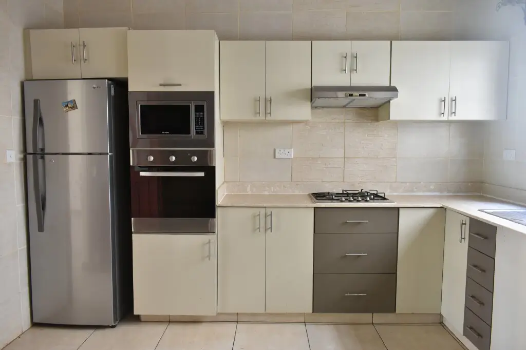 Modern kitchen with cream cabinets, stainless steel appliances, gas cooktop