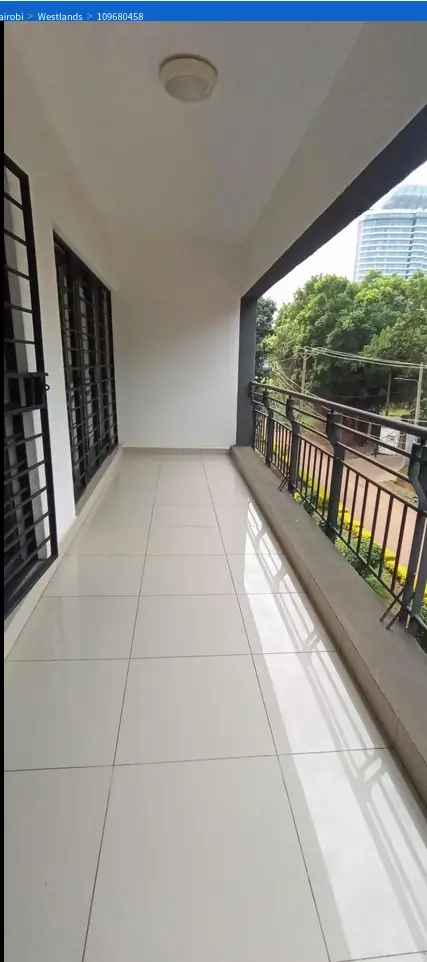 Spacious covered balcony with city and greenery views