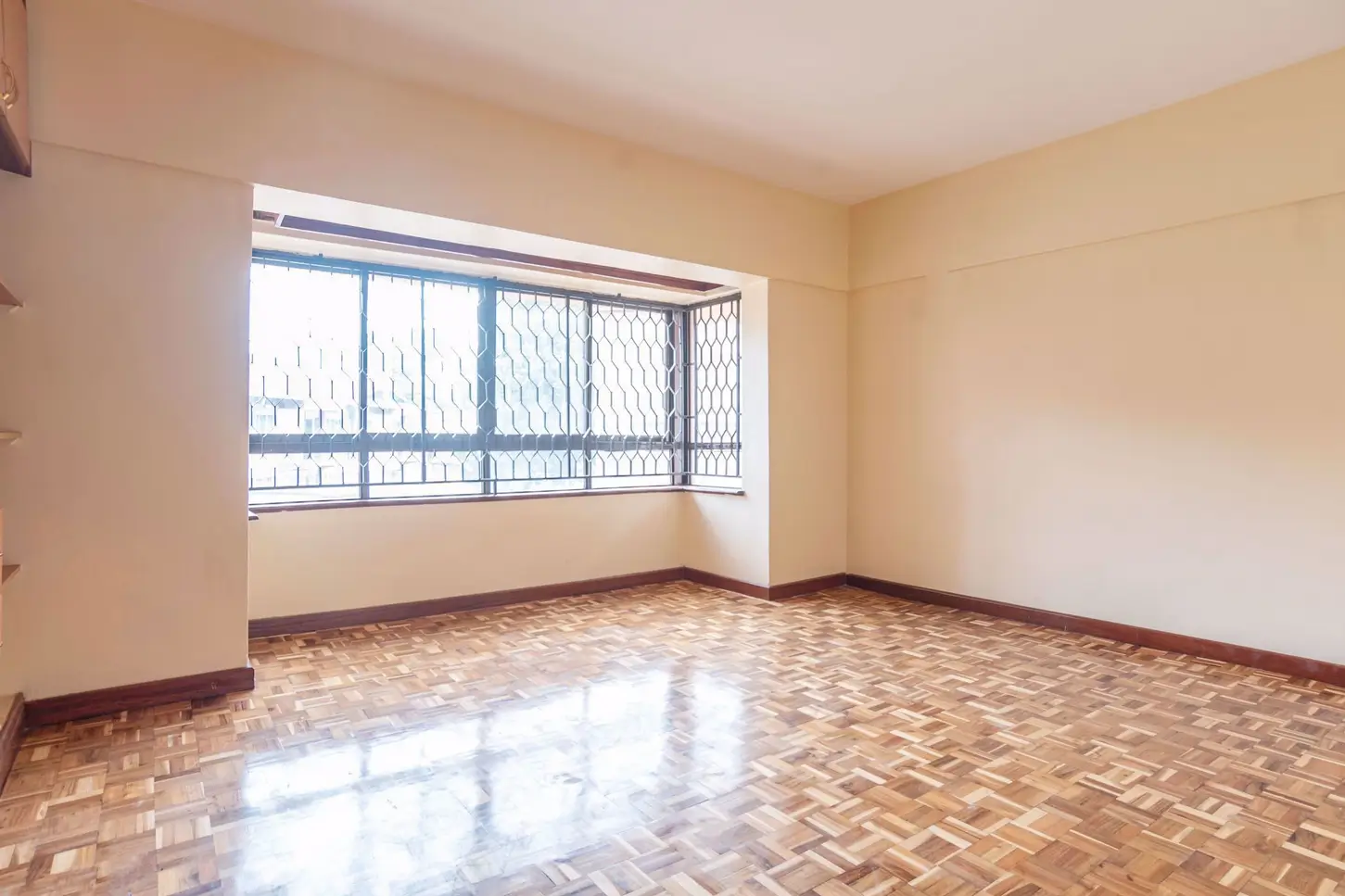 Spacious living room with herringbone floor and balcony access