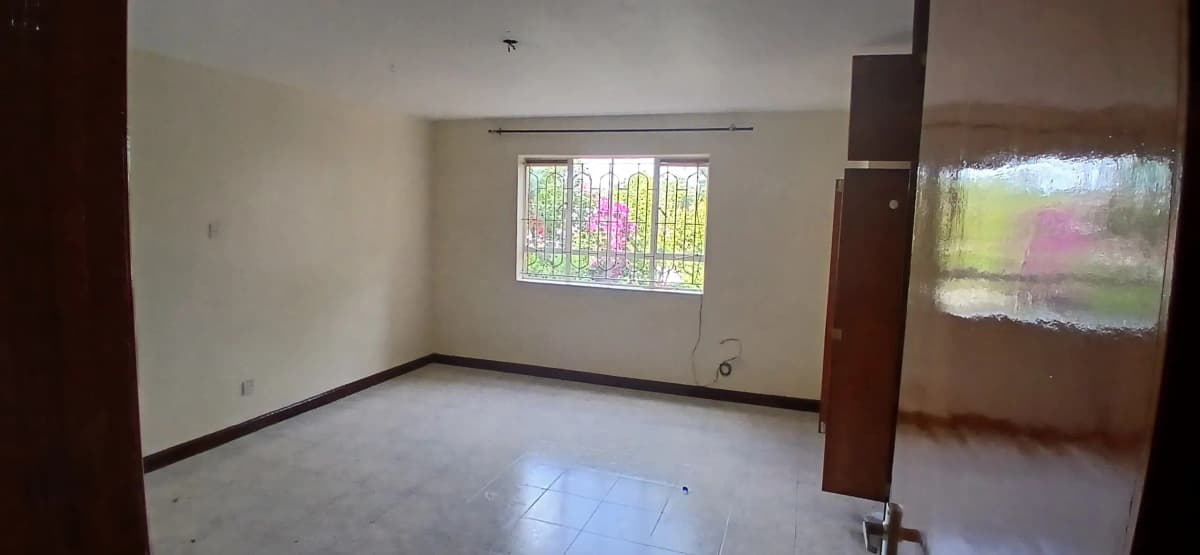 Spacious empty living room with natural light and wooden pillars