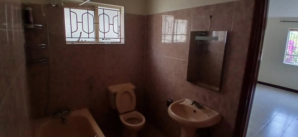 Basic bathroom with toilet, sink, and tiled walls