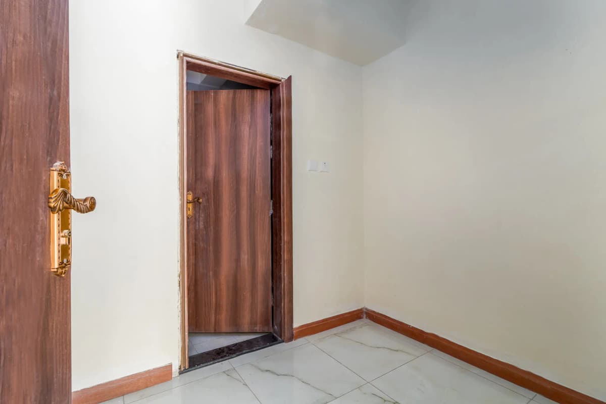 Hallway entrance with wooden doors and tiled flooring