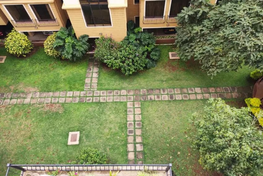 Manicured compound garden with pathways and shrubs