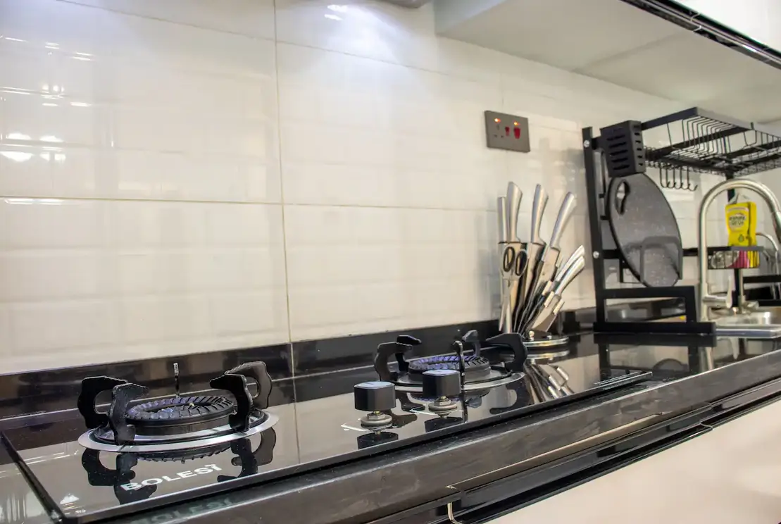 Modern kitchen with black gas cooktop and white tile backsplash