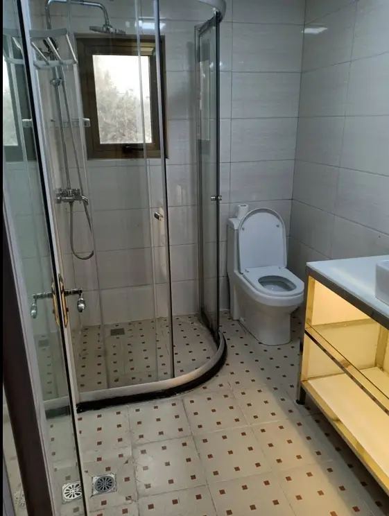 Modern bathroom with walk-in shower, toilet, and yellow vanity