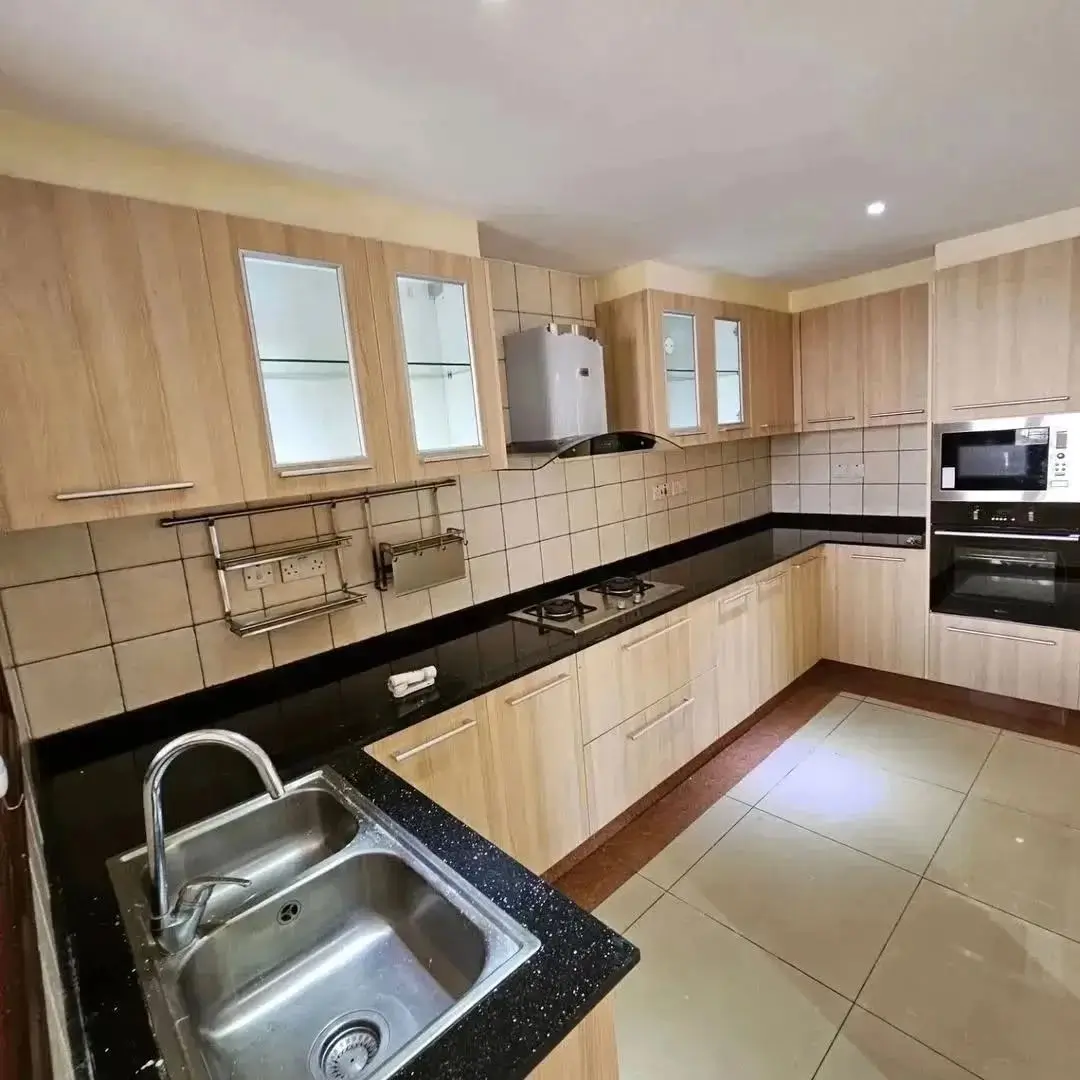 Spacious kitchen with black granite counters and light wood cabinets