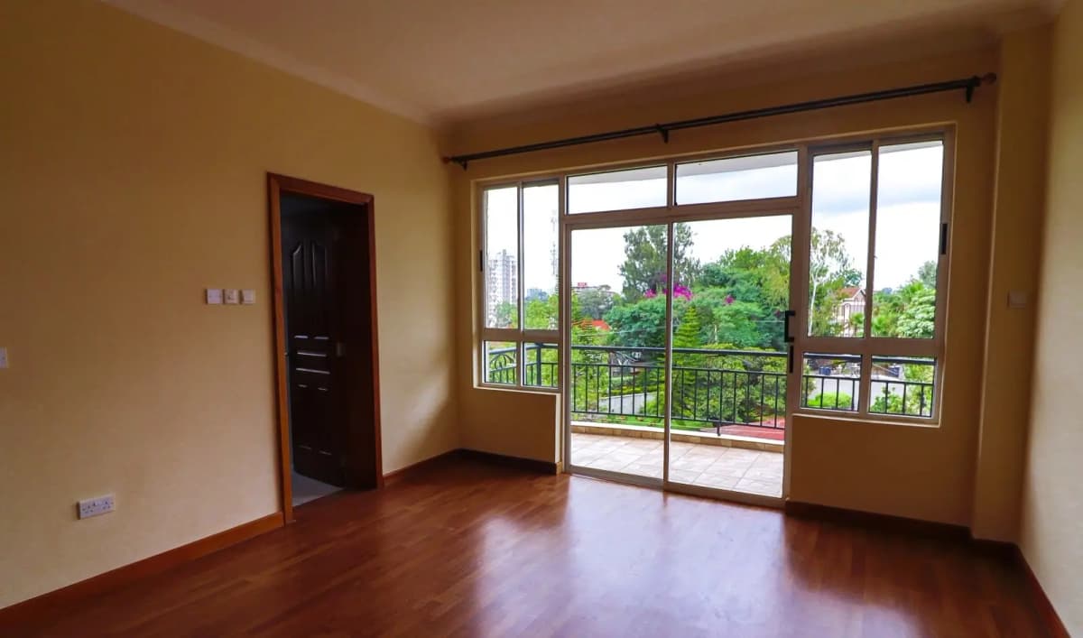 Spacious living room with glass doors opening to green views