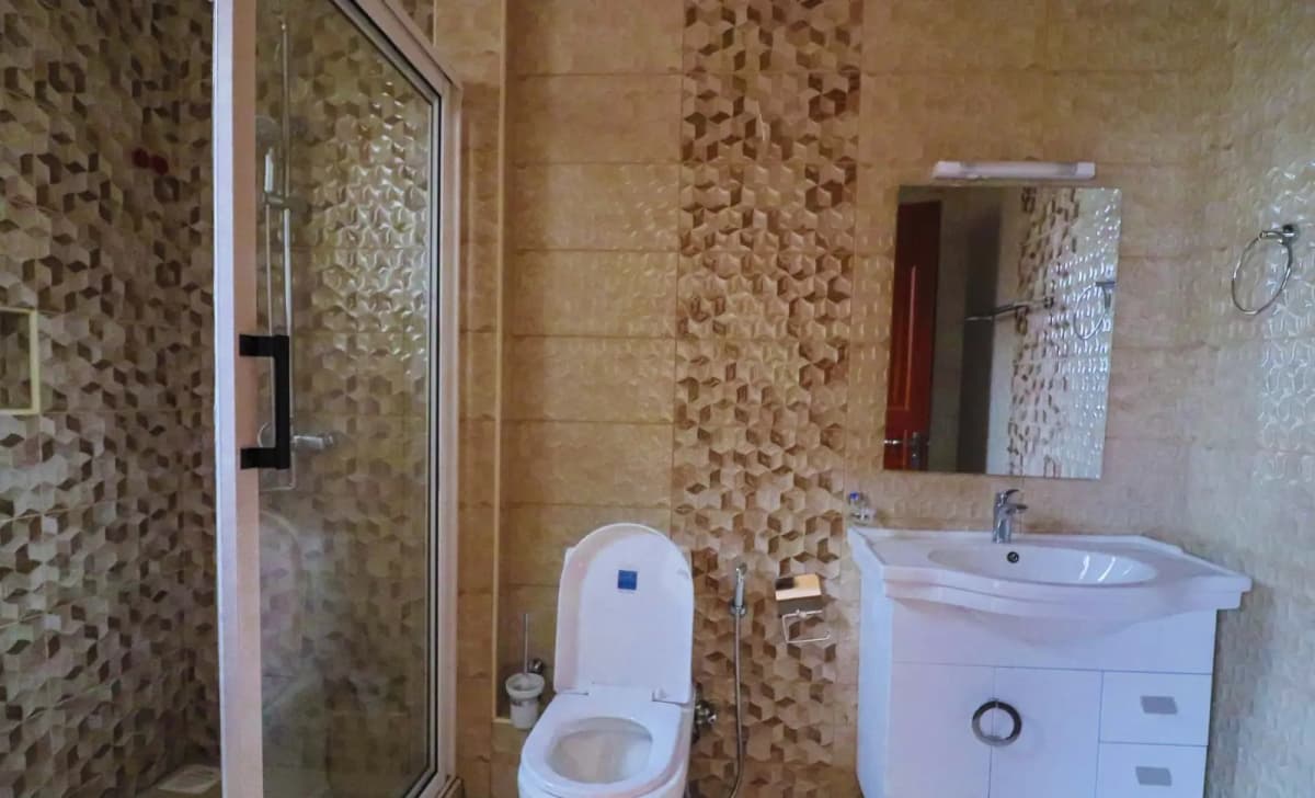 Bathroom with mosaic tile walls, toilet, and vanity sink