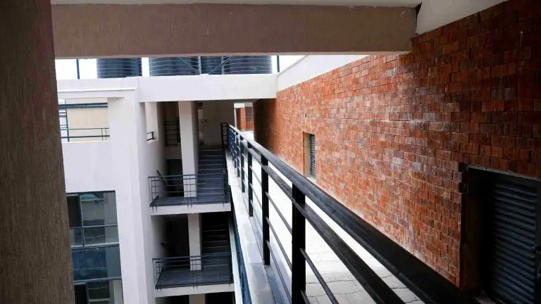 Modern balcony with black railings overlooking courtyard