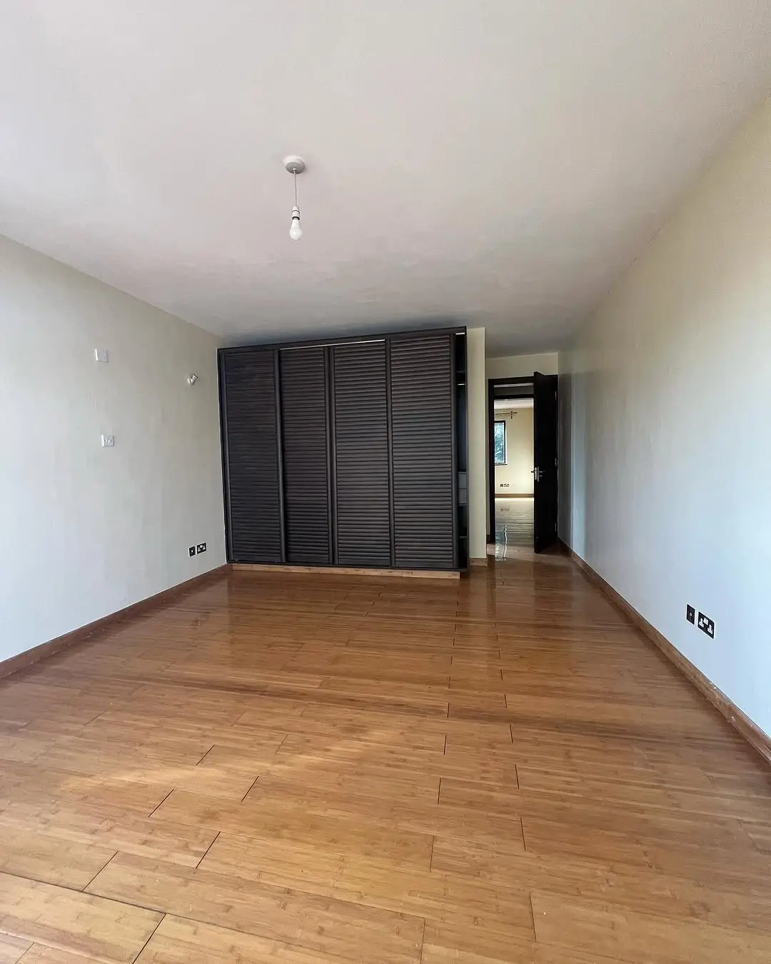 Spacious bedroom with wooden flooring and built-in wardrobe