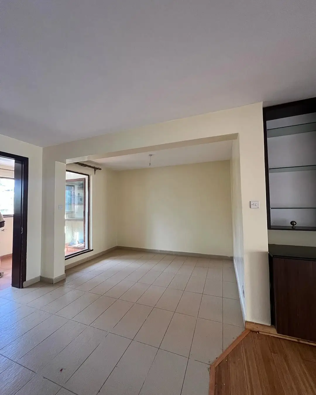 Spacious open-plan living area with tiled flooring and natural light