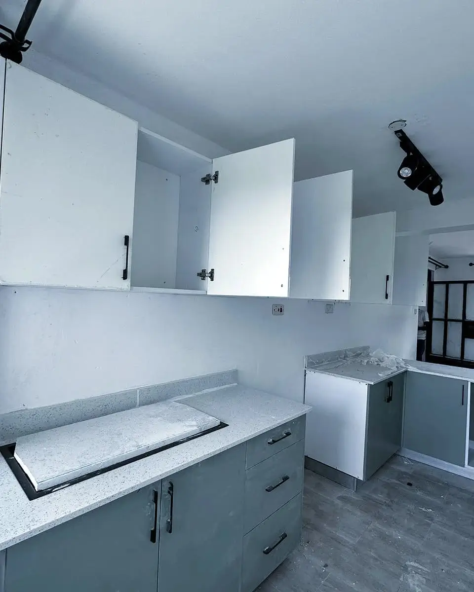 Modern kitchen with white cabinetry and grey marble countertops