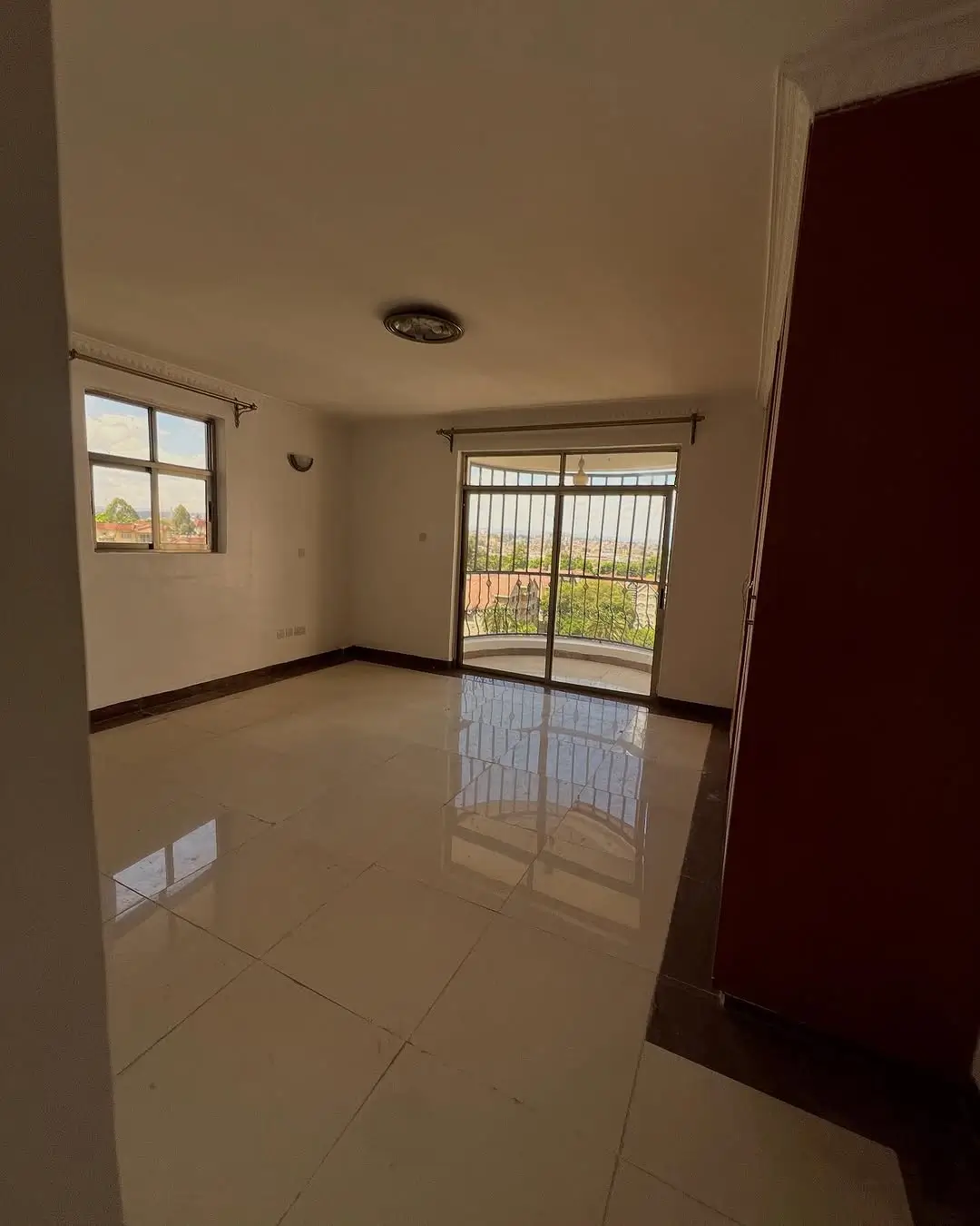 Spacious living room with polished tile floors and glass doors