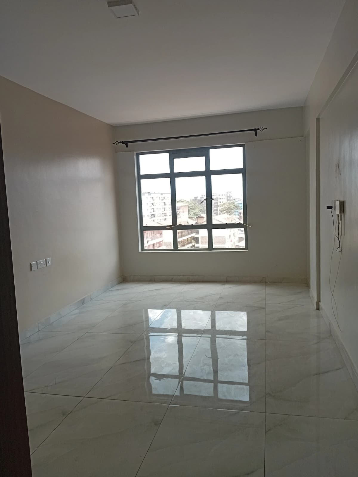 Bright unfurnished living room with polished marble flooring