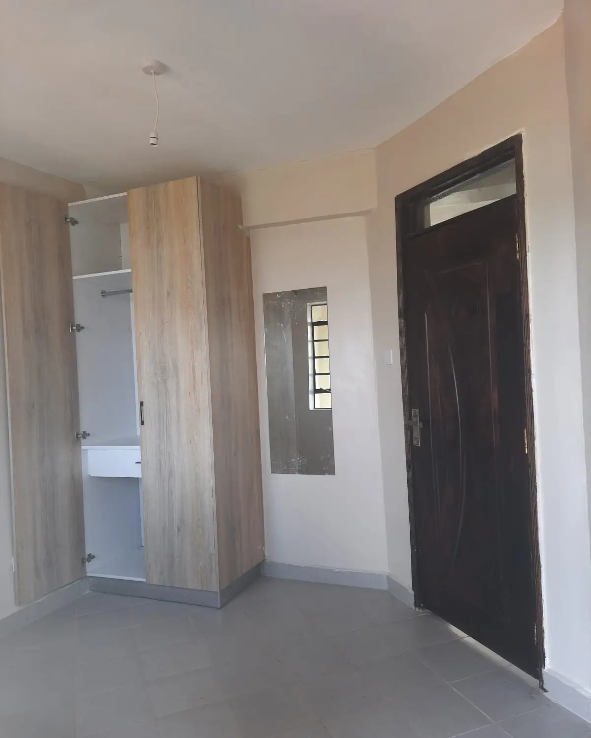 Entrance lobby with black door and wooden wardrobe cabinet