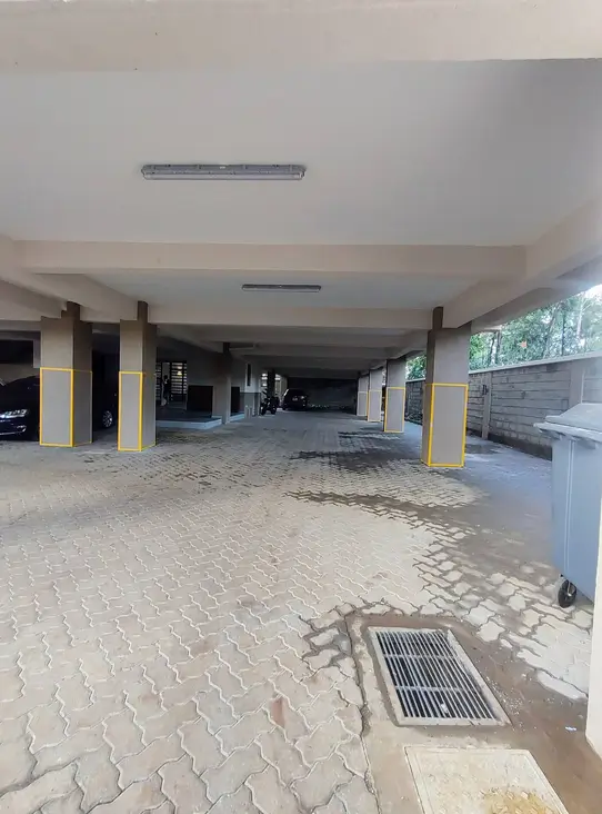 Covered basement parking area with yellow support pillars