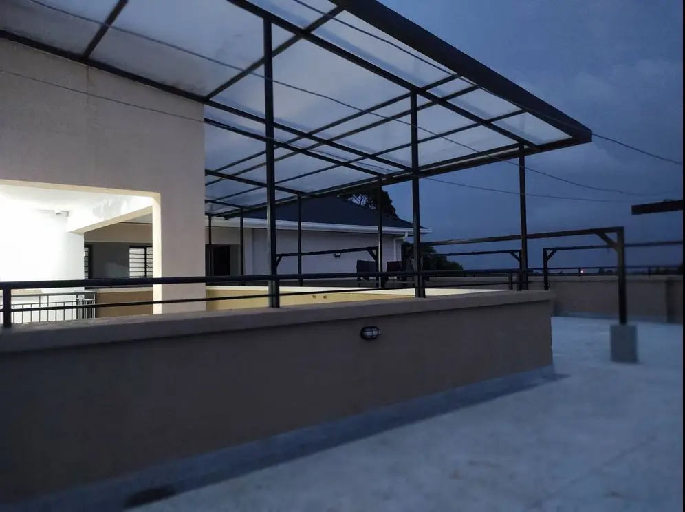 Rooftop terrace with metal railings and sunset skyline views