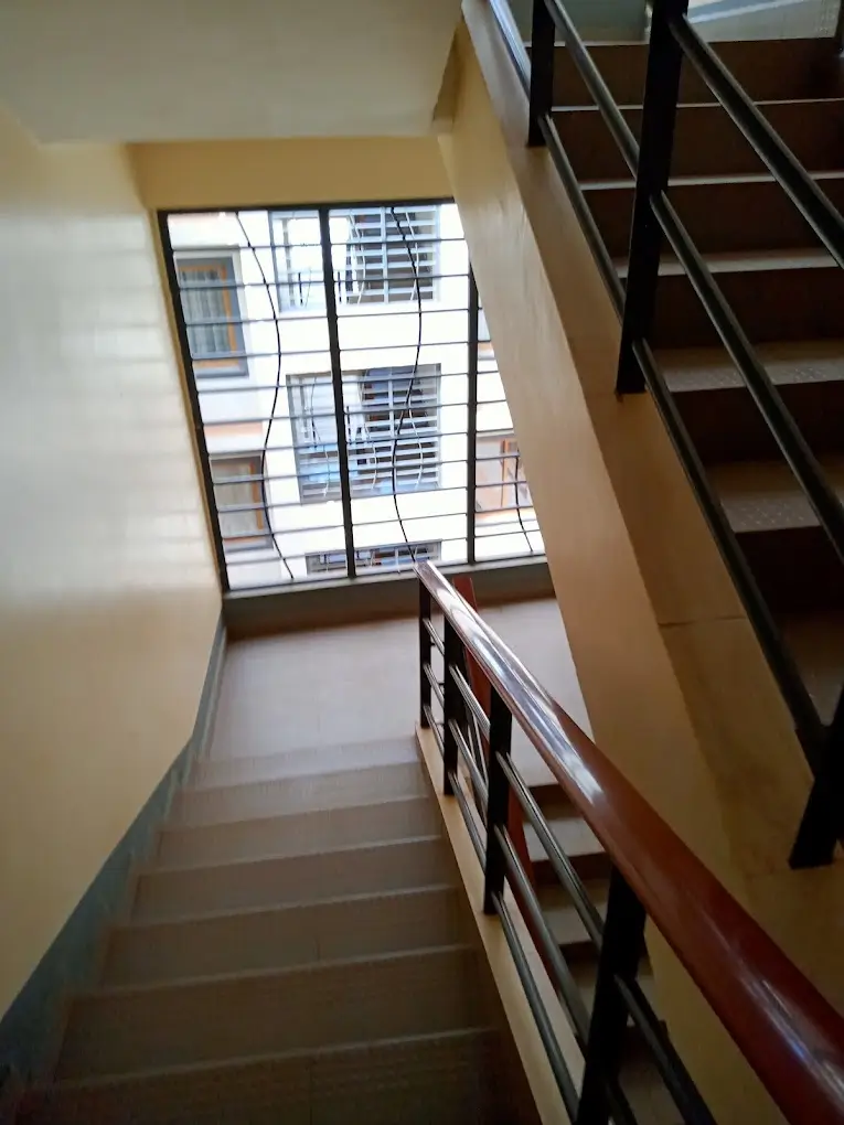 Multi-story stairwell with large window and metal railings