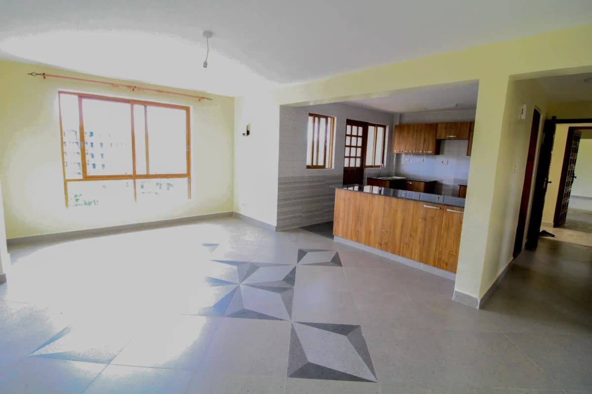 Open-plan living area with kitchen visible, yellow walls, natural light