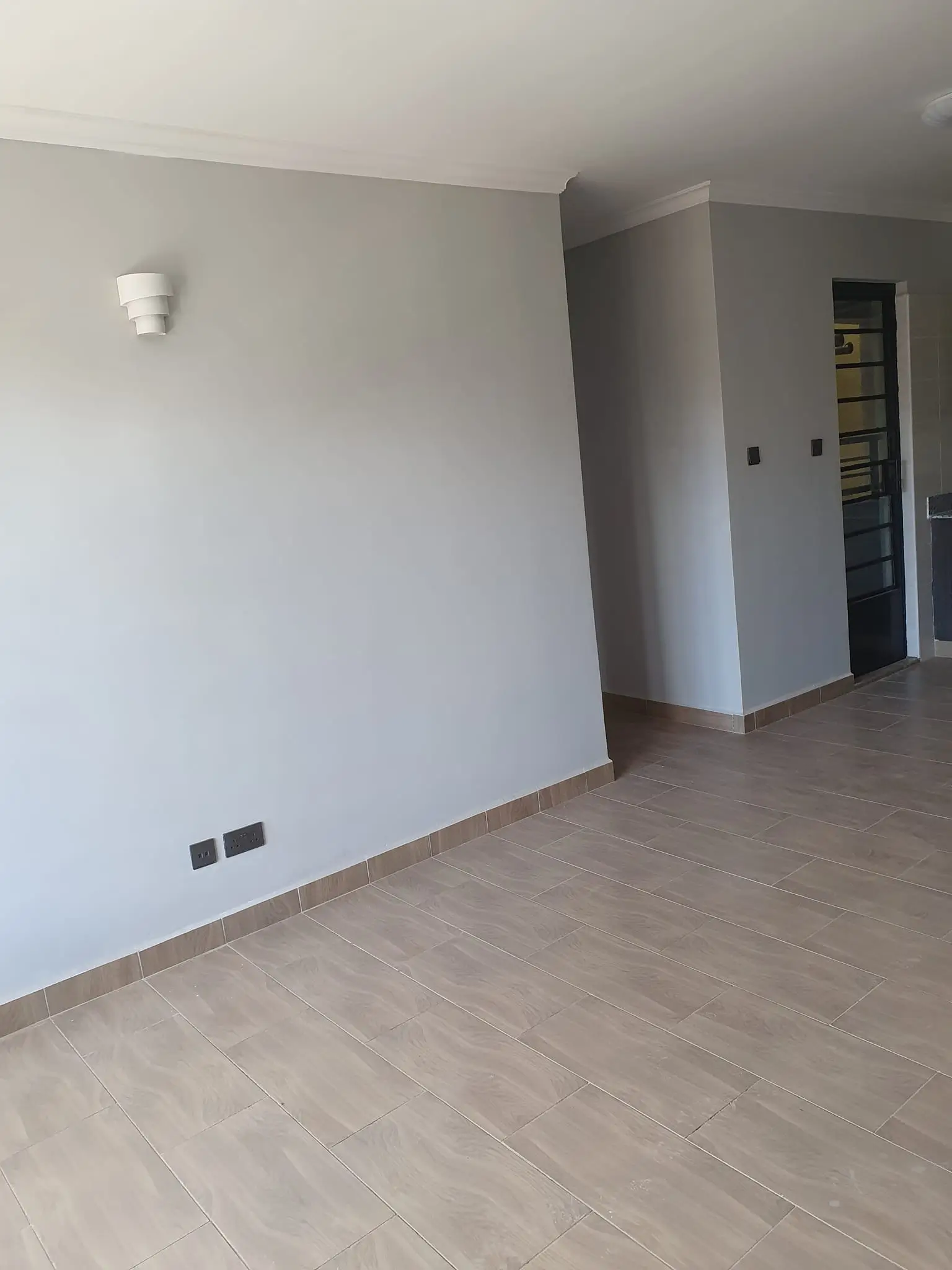 Empty living room with wooden flooring and neutral walls