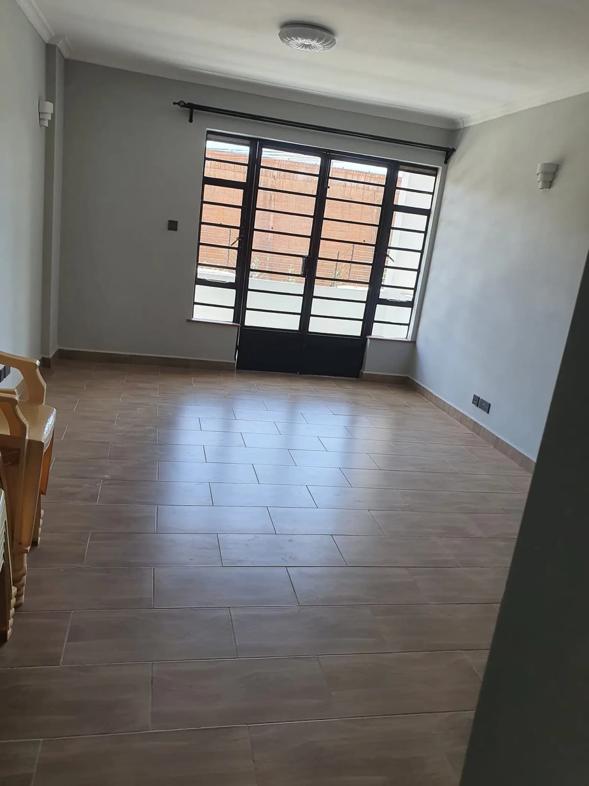 Spacious living room with wooden flooring and louvered doors