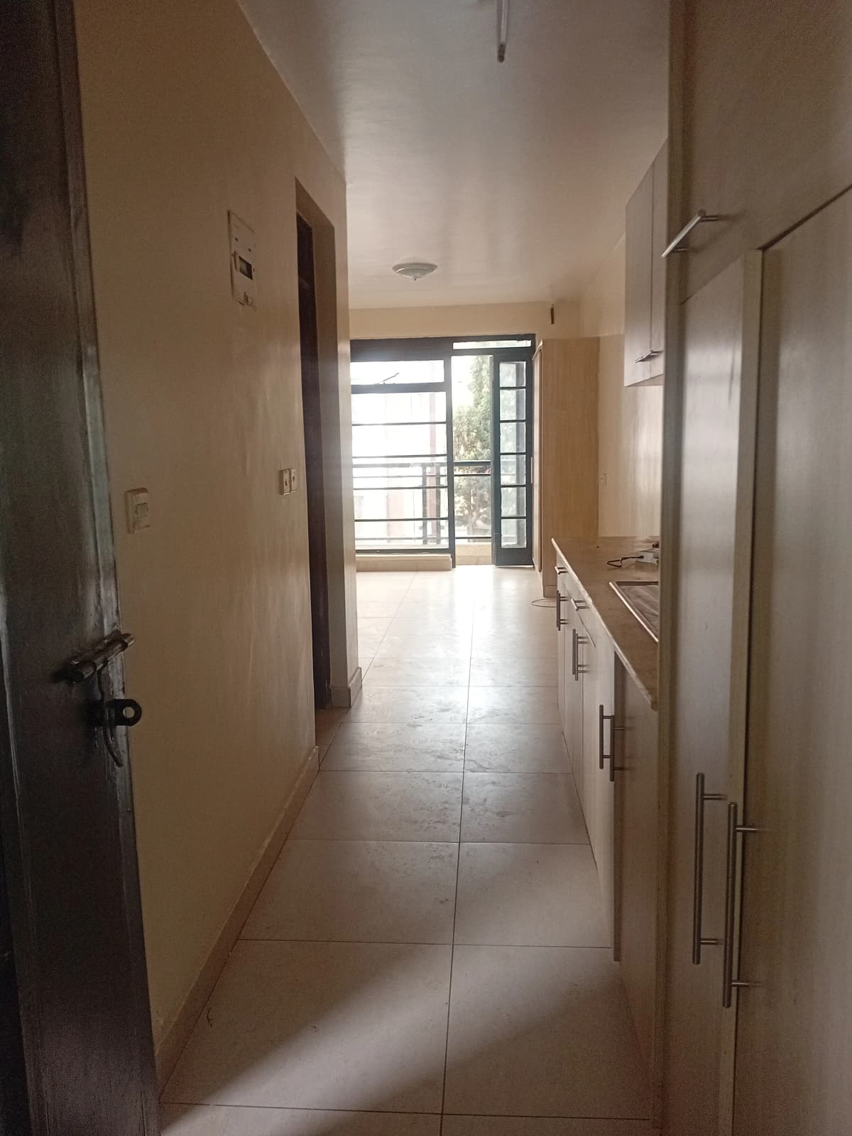 Bright corridor with tiled flooring and multiple doors