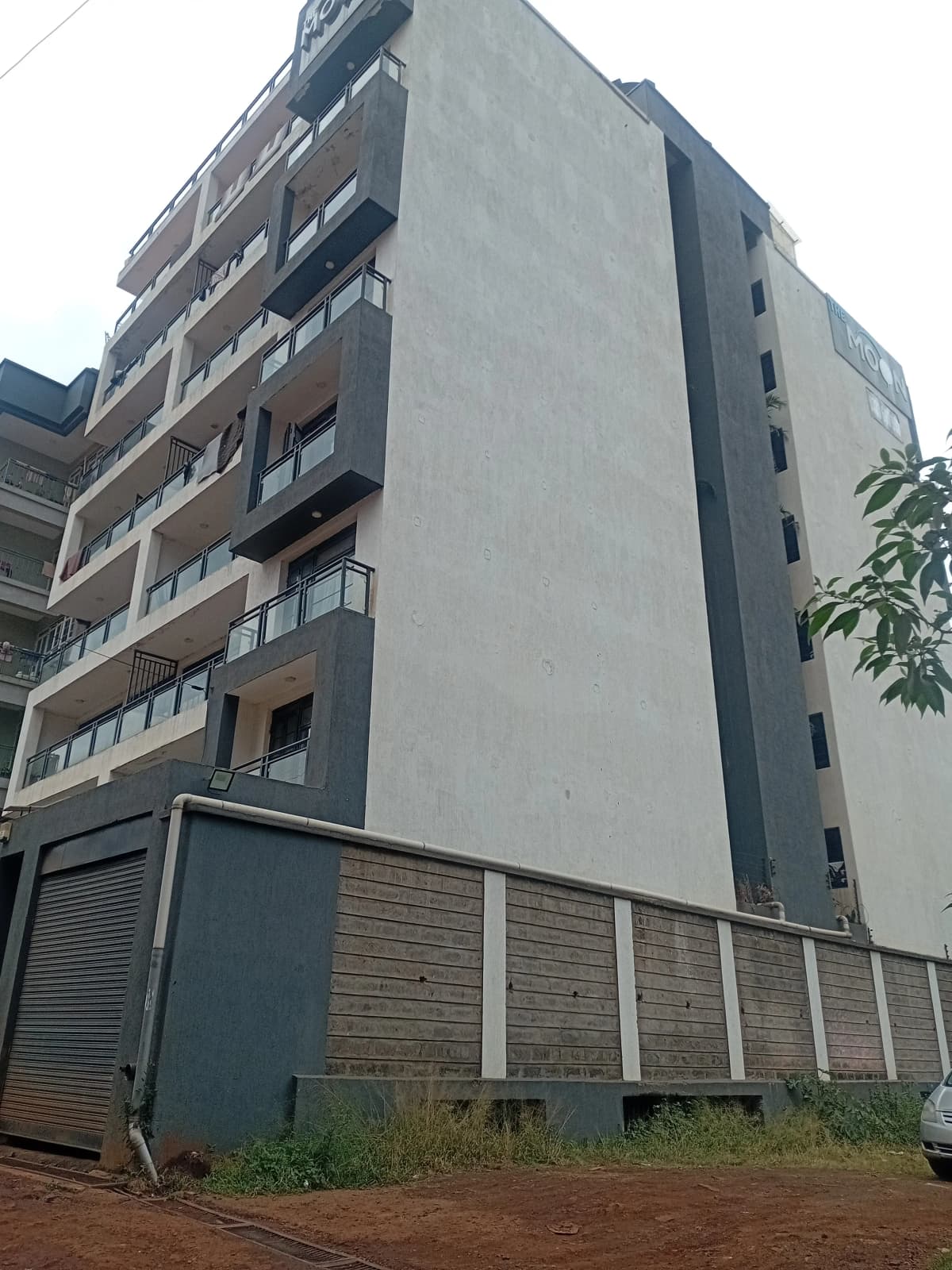 Modern multi-story residential building with balconies and parking