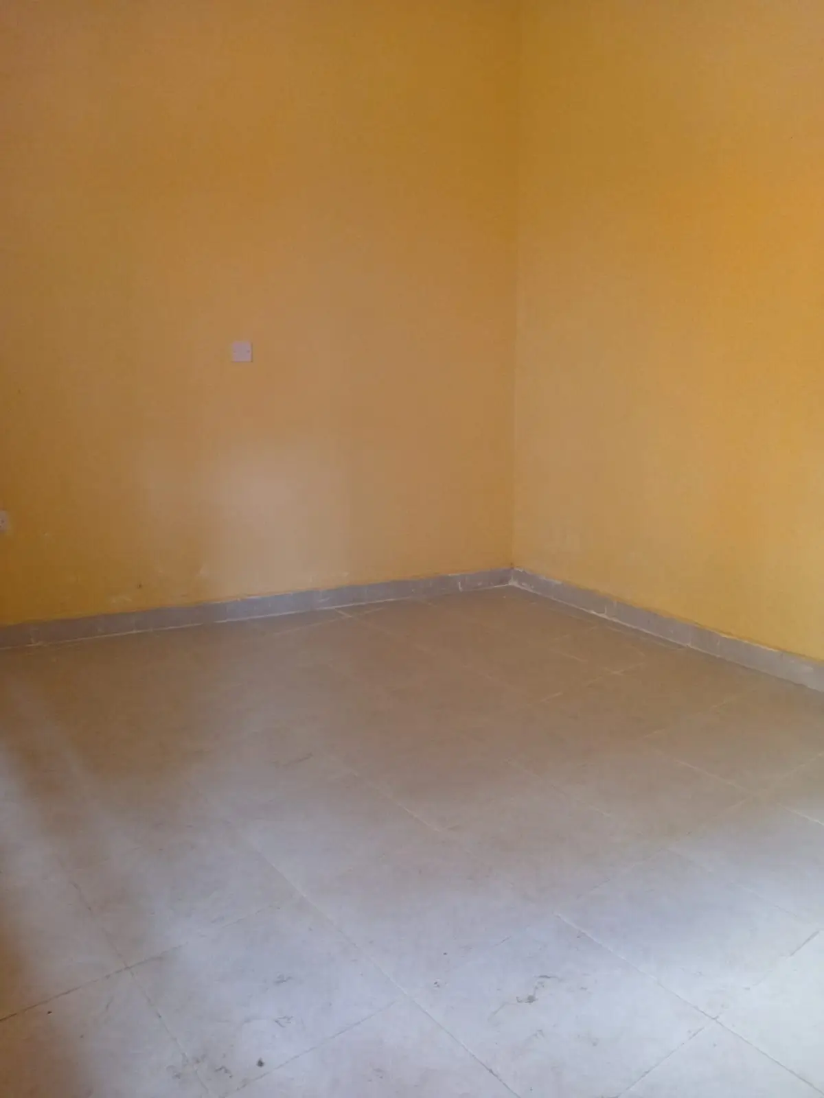 Empty room with yellow walls and concrete floor