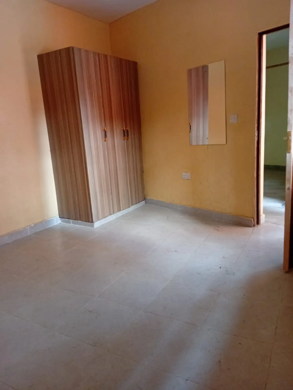 Empty bedroom with wooden wardrobe and beige walls