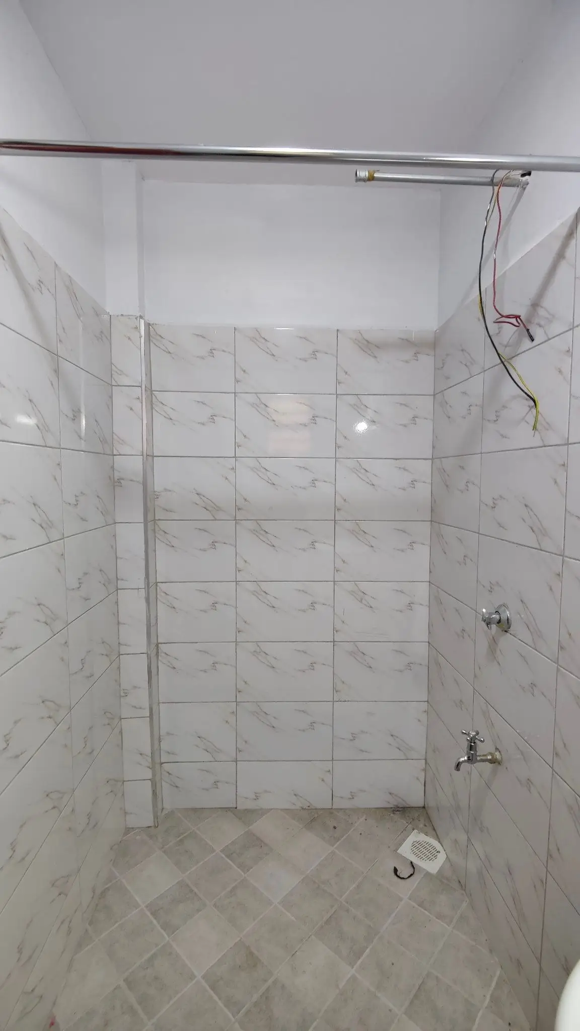 Marble-tiled shower enclosure with rainfall showerhead