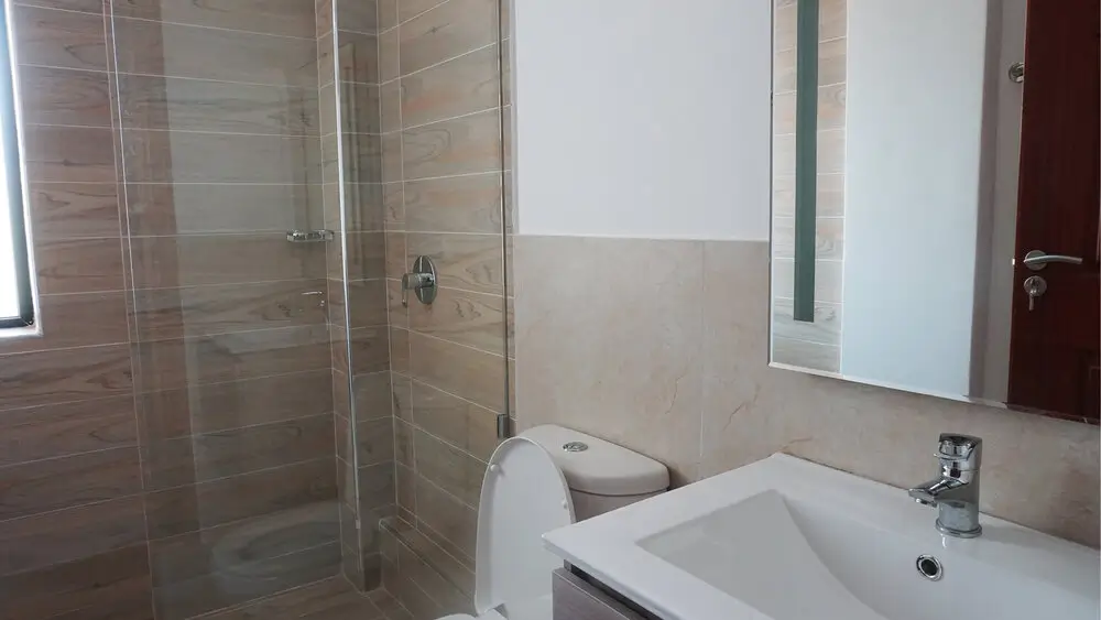Clean bathroom with shower enclosure, toilet, and white sink