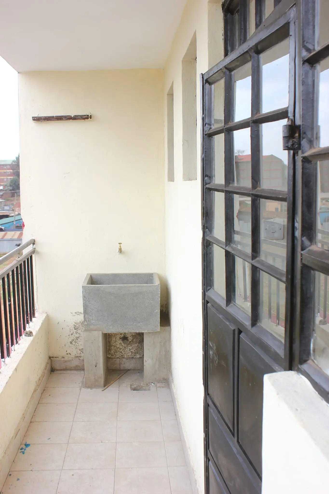 Narrow balcony with concrete planter and metal railings