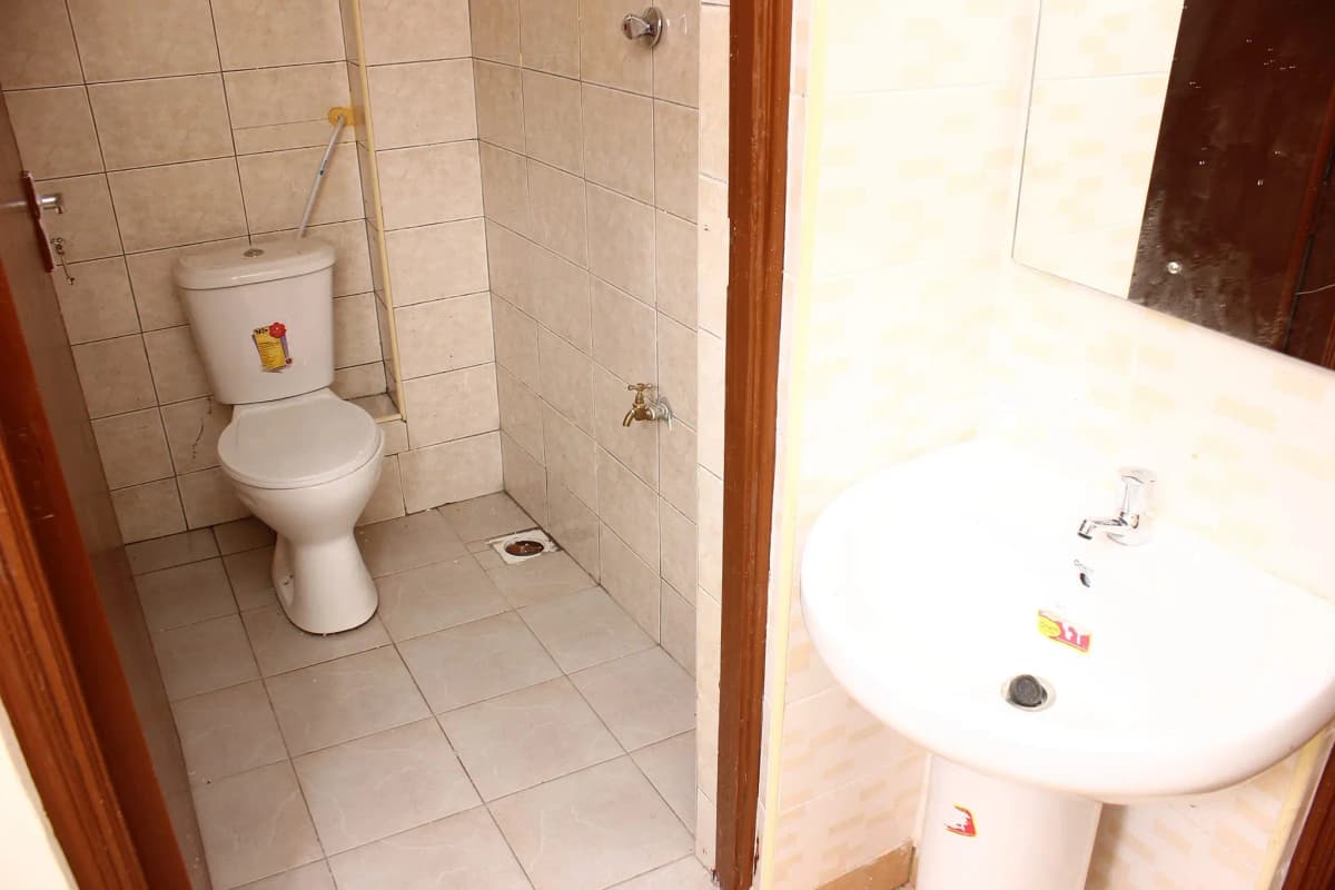 Basic bathroom with toilet, sink, and tiled walls