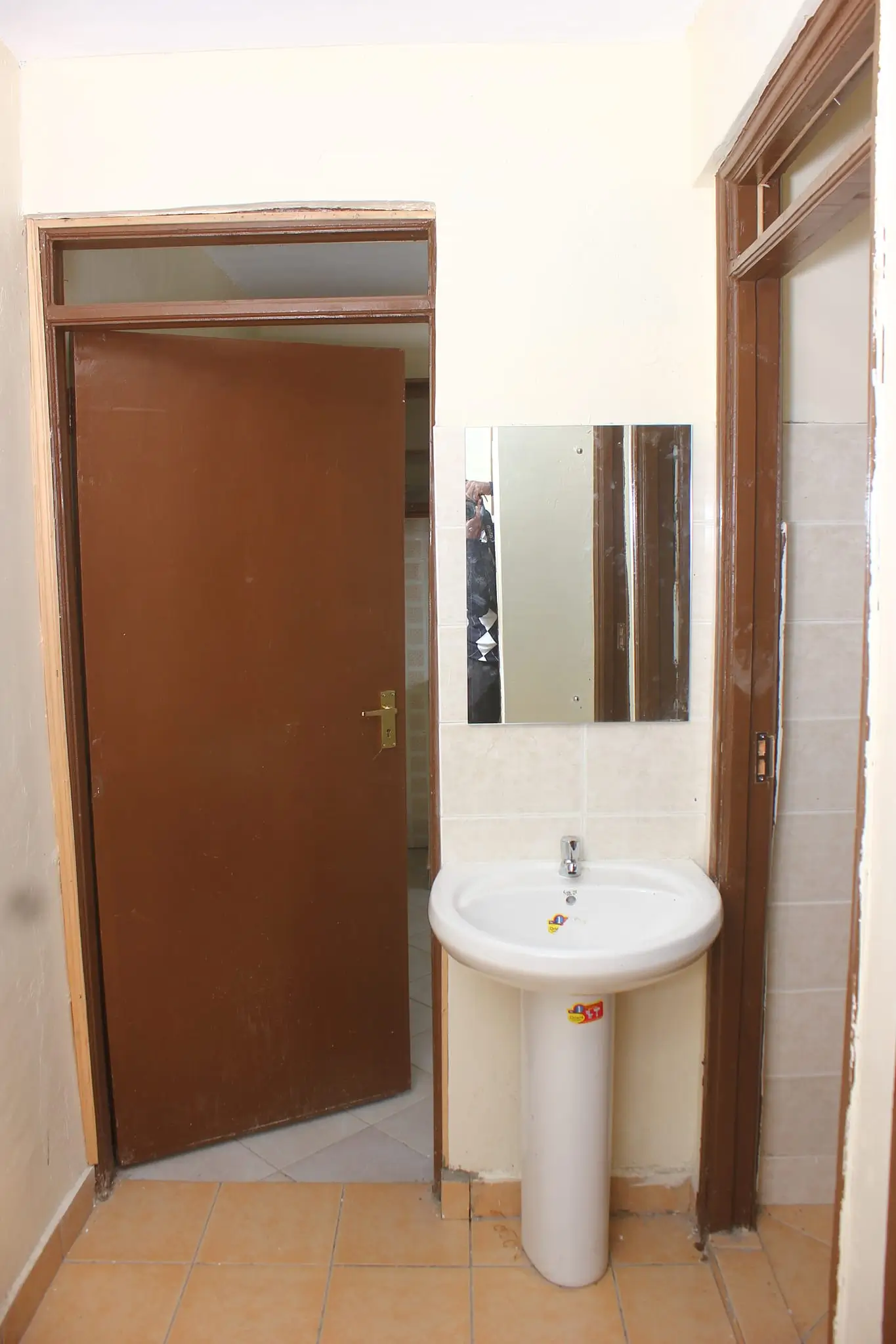 Compact bathroom with pedestal sink and mirror