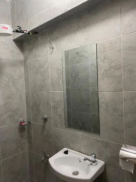 Modern bathroom with gray tile walls and white pedestal sink