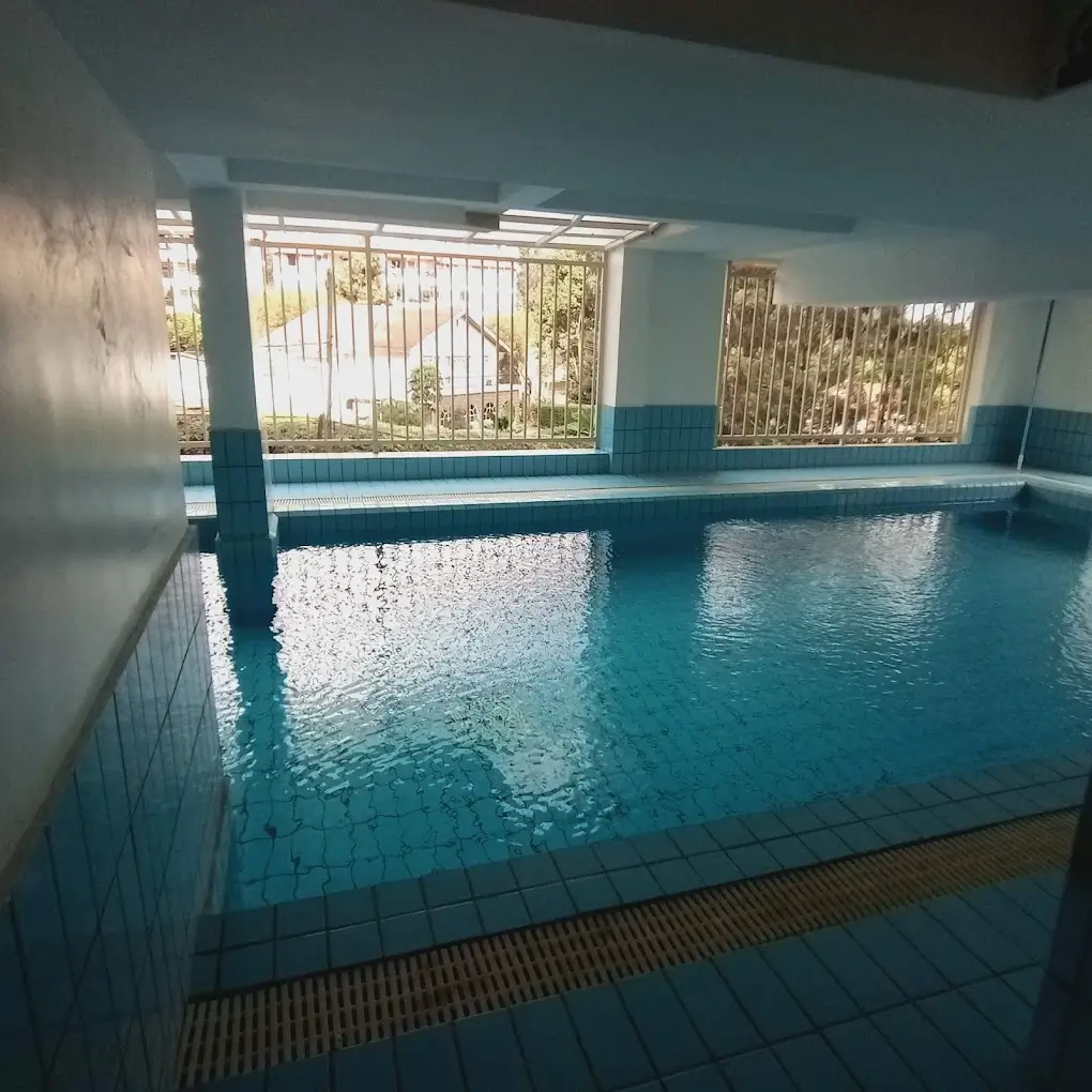 Indoor swimming pool with blue tiles and support columns