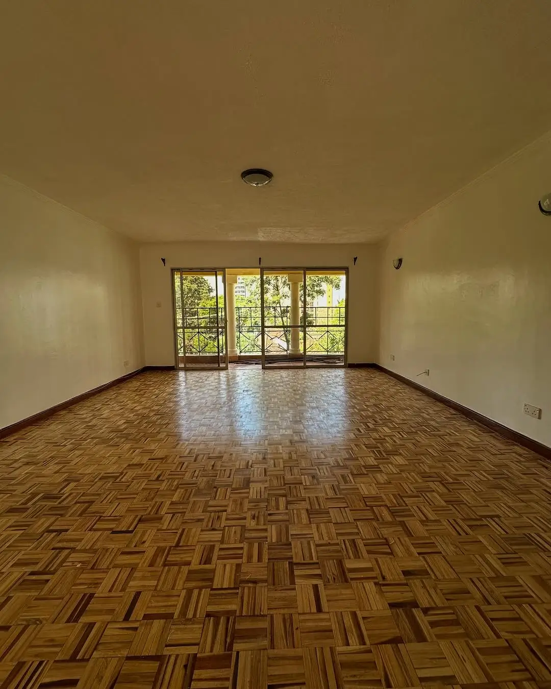 Spacious living room with parquet flooring and garden views