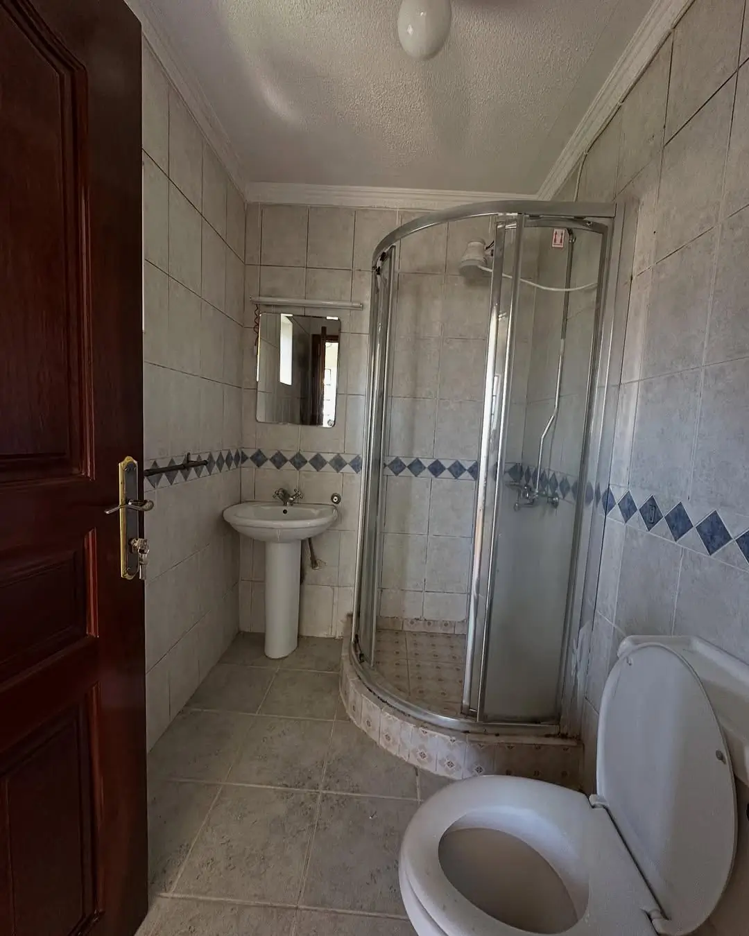 Bathroom with shower enclosure, pedestal sink, toilet